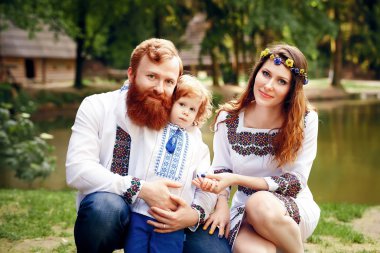 Happy family with little son in traditional ukrainian dress clipart
