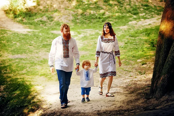 Família feliz com filho pequeno em vestido tradicional ucraniano — Fotografia de Stock