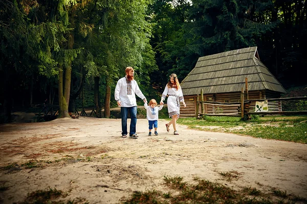 Família feliz com filho pequeno em vestido tradicional ucraniano — Fotografia de Stock