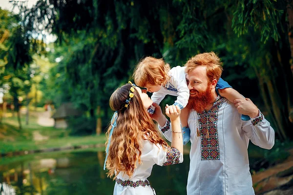 Família feliz com filho pequeno em vestido tradicional ucraniano — Fotografia de Stock