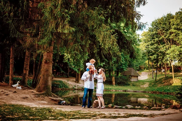 Família feliz com filho pequeno em vestido tradicional ucraniano — Fotografia de Stock