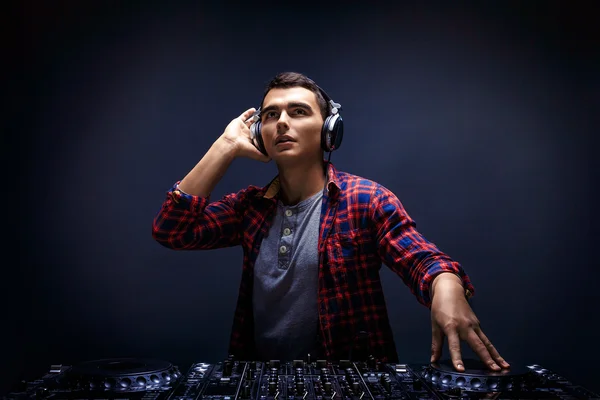 Jovem toca música em um mixer de djs no estúdio — Fotografia de Stock