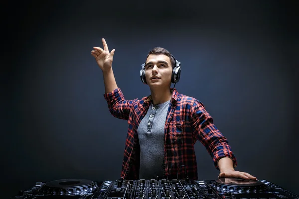 Jovem toca música no mixer de um DJ no estúdio — Fotografia de Stock