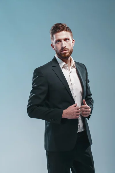 Estudio de un hombre barbudo con estilo en traje elegante, fondo tiffany de color, aislar — Foto de Stock