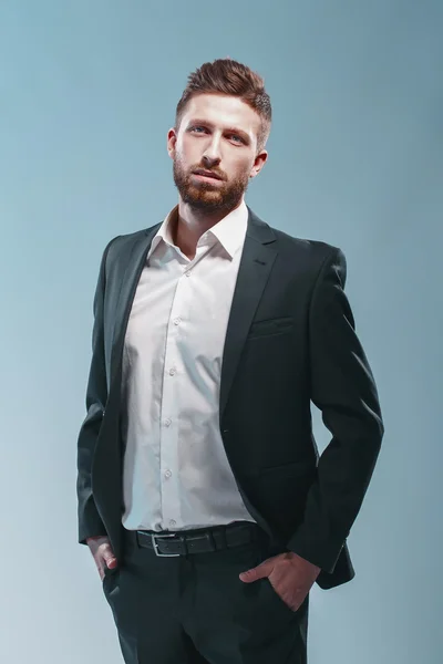 Estúdio tiro de um homem barbudo elegante em terno elegante, fundo Tiffany colorido, isolar — Fotografia de Stock