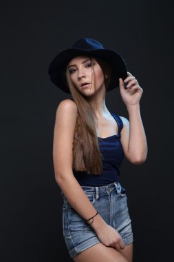 Şapkalı güzel bir kadın. Koyu arka plan.