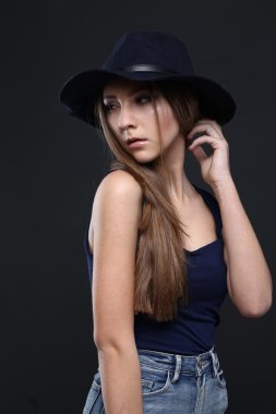 Şapkalı güzel bir kadın. Koyu arka plan.