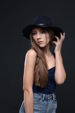 Şapkalı güzel bir kadın. Koyu arka plan.