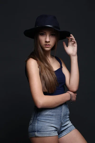 Uma bela mulher de chapéu. Fundo escuro . — Fotografia de Stock