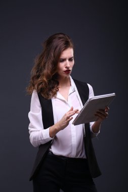 Koyu arka plan üzerinde beyaz tablet ile güzel bir kadın portresi. Stüdyo vurdu.