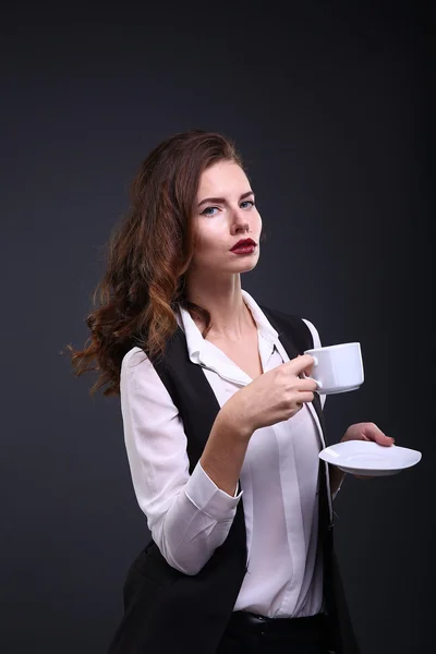 Wanita bisnis cantik memegang secangkir kopi putih dengan latar belakang gelap. Rekaman studio — Stok Foto