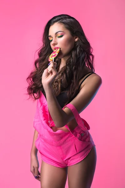 사탕을 들고는 분홍색 낙하산 강 하복에서 섹시 한 젊은 여자. — 스톡 사진