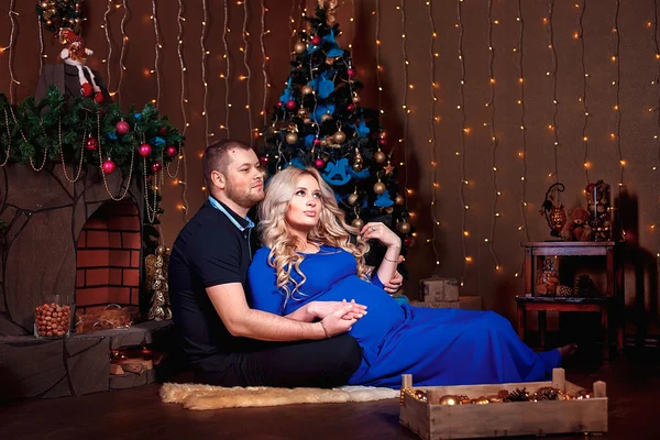 Familia feliz en la sala de estar, detrás del árbol de Navidad decorado, la luz da un ambiente acogedor. Tema Año Nuevo y Navidad —  Fotos de Stock