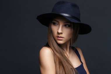 Şapkalı güzel bir kadın. Koyu arka plan.