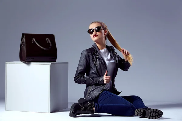 Portrait of Vogue style beautiful young blond woman with black bag near cube in studio — 图库照片
