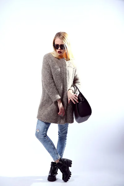 Sexy Beauty Girl. Fashion Blonde. Portrait of a girl dressed in grey coat, wearing a black bag, posing on a studio background. — Φωτογραφία Αρχείου