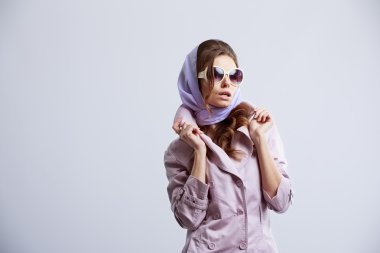 Genç pembe ceket ve beyaz güneş gözlüğü takmış Studio'da poz kadın moda. 