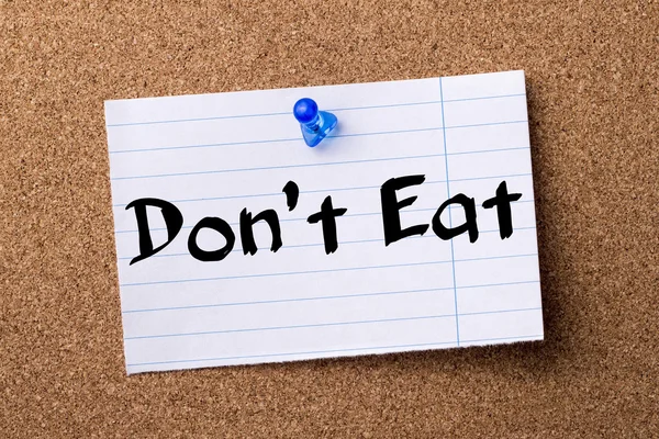 Don't Eat - teared note paper pinned on bulletin board — Stock Photo, Image