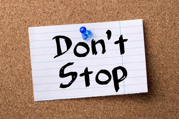 Don 't Stop - papel de nota desgarrado fijado en el tablón de anuncios —  Fotos de Stock