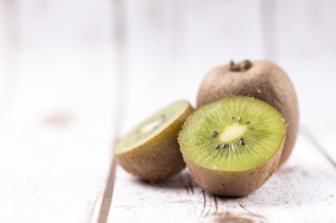 Beyaz ahşap zemin üzerinde taze kivi meyve