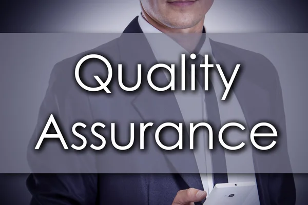 Quality Assurance - Young businessman with text - business conce — Stock Photo, Image