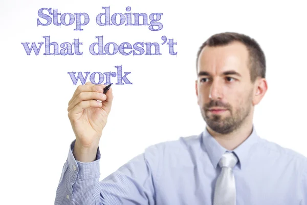 Sluta göra vad som inte fungerar - ung affärsman skriver blå text — Stockfoto