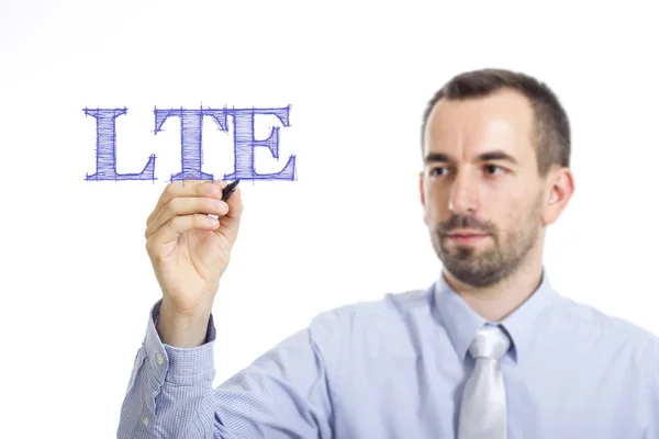 LTE - Jovem empresário escrevendo texto azul na superfície transparente — Fotografia de Stock