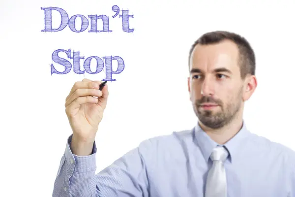 Don't Stop - Young businessman writing blue text on transparent surface — Stock fotografie