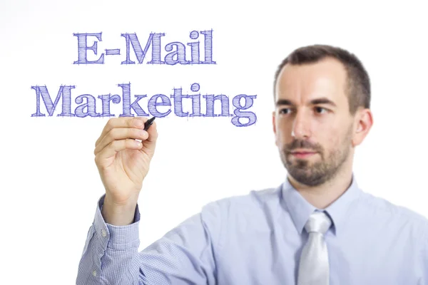 E-Mail Marketing - Young businessman writing blue text on transparent surface — Zdjęcie stockowe