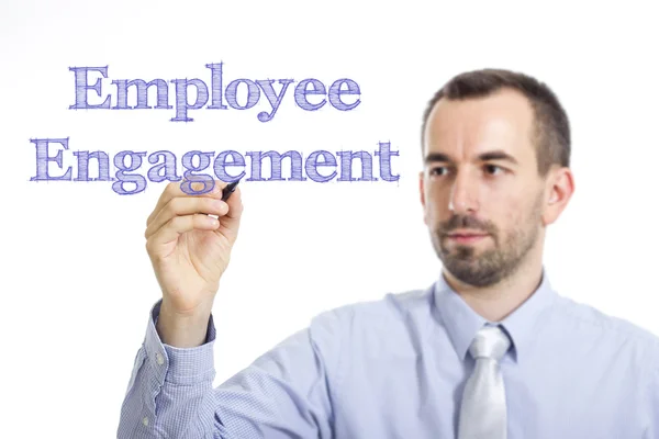 Employee Engagement - Jovem empresário escrevendo texto azul na superfície transparente — Fotografia de Stock