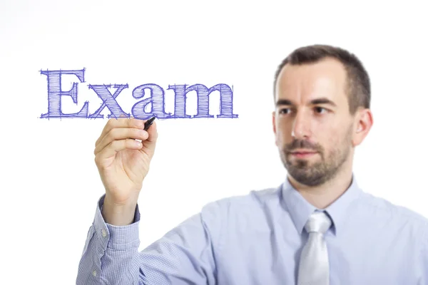 Exam - Young businessman writing blue text — Stock fotografie