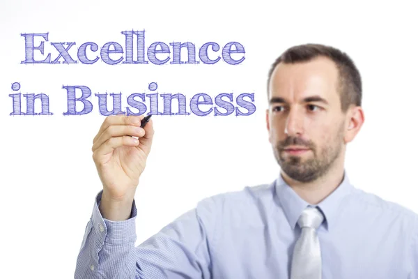 Excellence in Business - Young businessman writing blue text — 图库照片