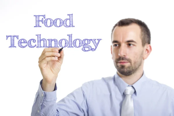 Technologie alimentaire - Jeune homme d'affaires écrivant du texte bleu sur une surface transparente — Photo