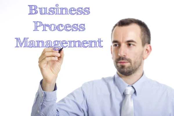 Business Process Management BPM - Jeune homme d'affaires écrivant du texte bleu sur une surface transparente — Photo