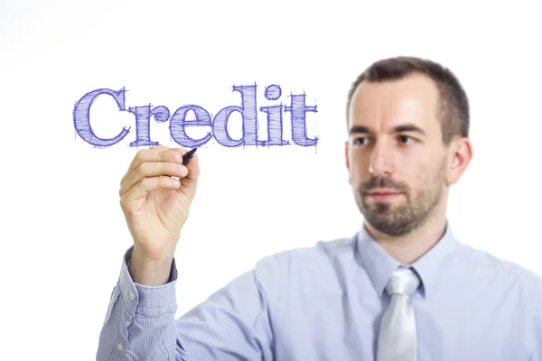 Credit - Young businessman with blue text — Stock Photo, Image