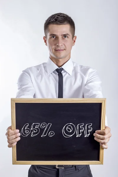 65 процентов скидки - Молодой бизнесмен держит доску — стоковое фото