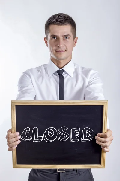 閉鎖 - テキストと黒板を保持している青年実業家 — ストック写真