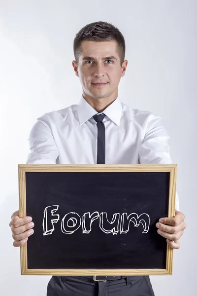 Fórum - fiatal üzletember gazdaság chalkboard — Stock Fotó
