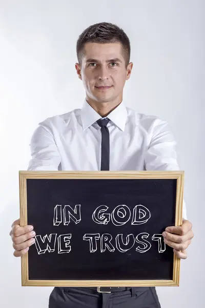 W Boga wierzymy - młody biznesmen posiadania tablicy — Zdjęcie stockowe
