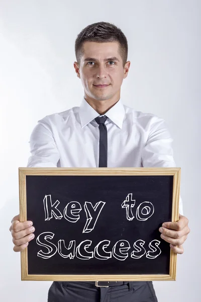 Chave para o sucesso - Jovem empresário segurando quadro — Fotografia de Stock