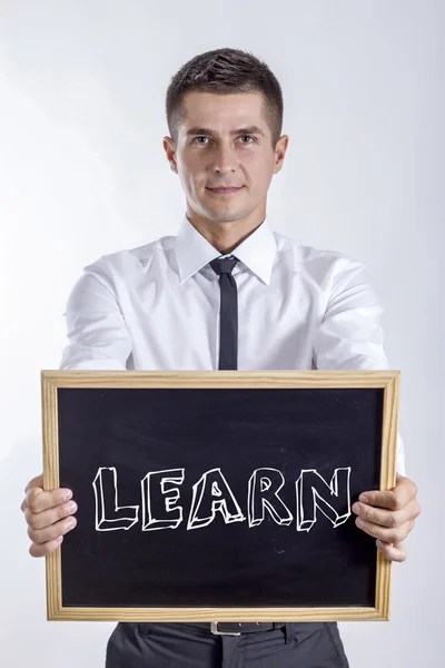 Learn - fiatal üzletember gazdaság chalkboard — Stock Fotó