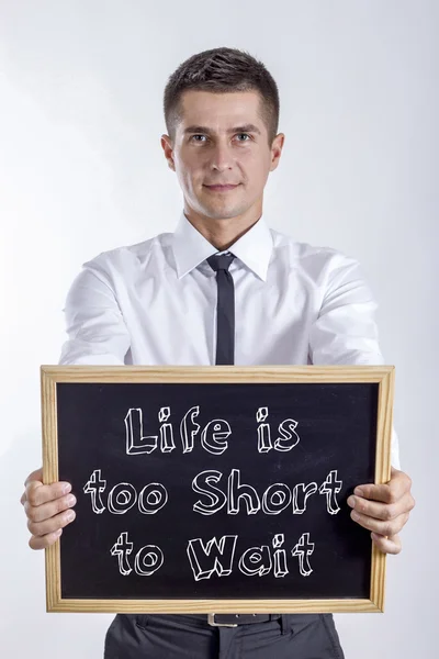 La vida es demasiado corta para esperar - Joven empresario sosteniendo pizarra — Foto de Stock