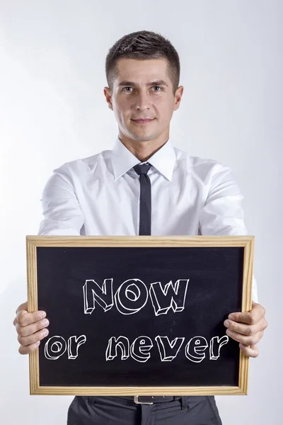Nu eller aldrig - ung affärsman holding svarta tavlan — Stockfoto