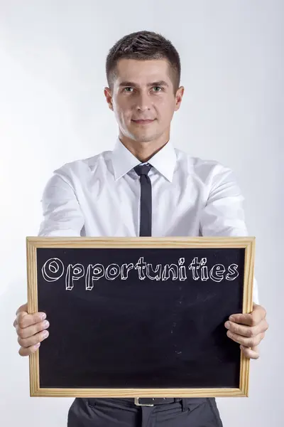 Möjligheter - ung affärsman holding svarta tavlan — Stockfoto