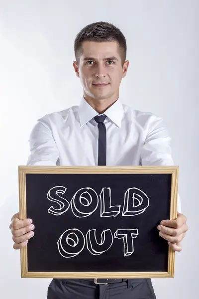 SOLD OUT - Jovem empresário segurando quadro — Fotografia de Stock