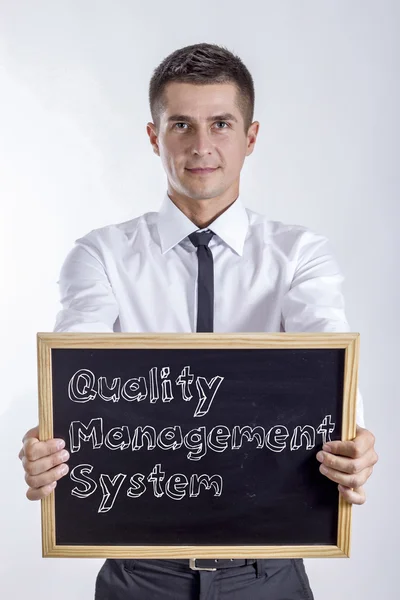 Sistema de Gestão da Qualidade QMS - Jovem empresário segurando quadro — Fotografia de Stock