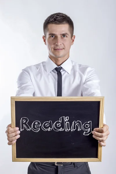 Czytanie - młody biznesmen posiadania tablicy — Zdjęcie stockowe