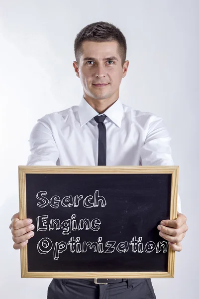 Search Engine Optimization - Young businessman holding chalkboard — Stock Photo, Image