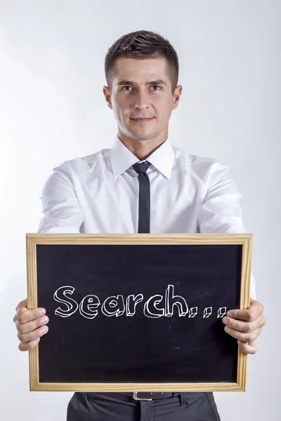 Search... - Young businessman holding chalkboard — Stock Photo, Image