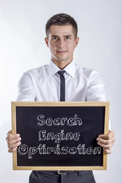 Search Engine Optimization - Young businessman holding chalkboard — Stock Photo, Image